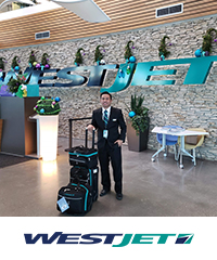 John Nagayo standing below Westjet signage